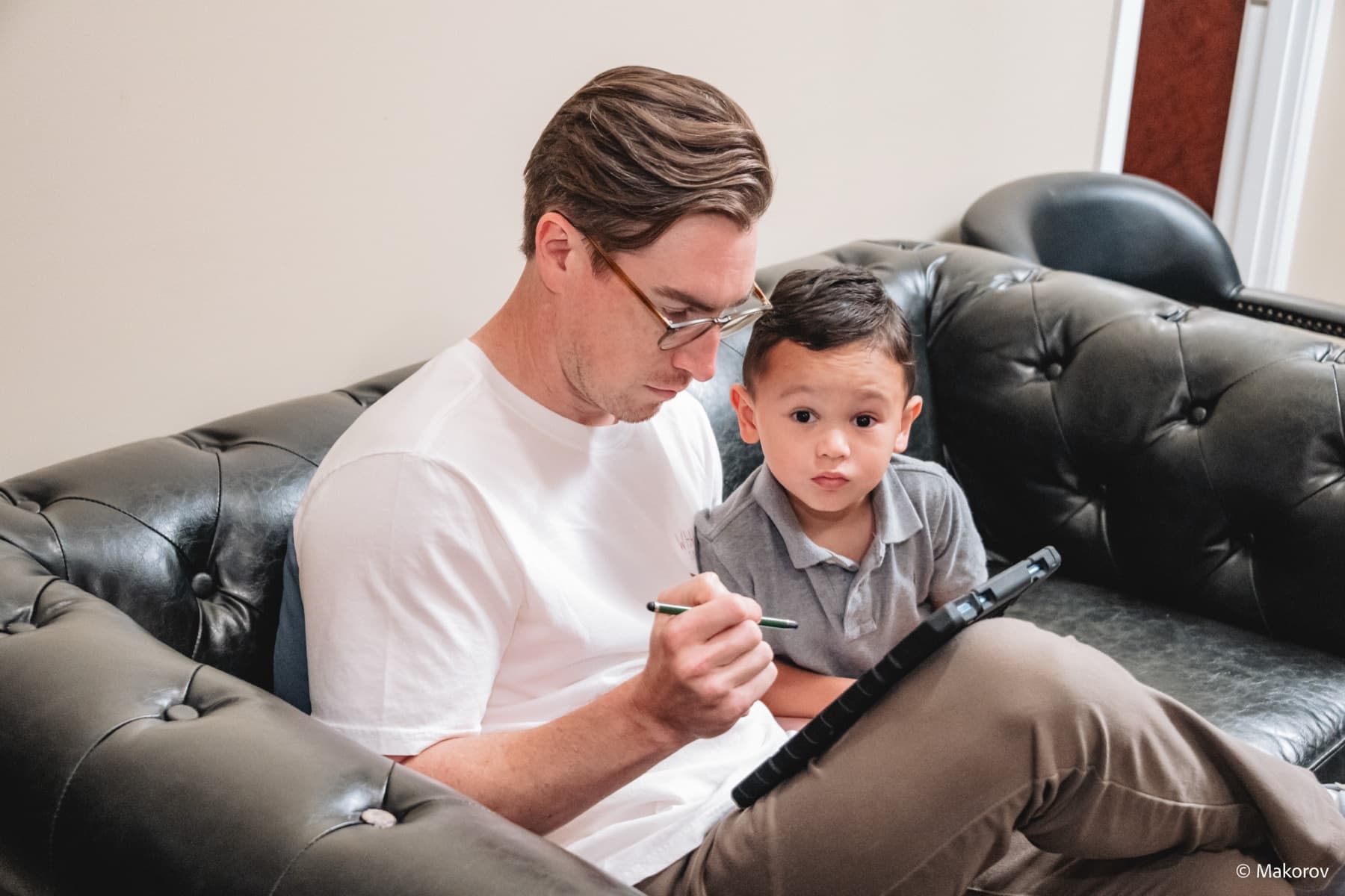 Father and son filling out forms in the waiting area