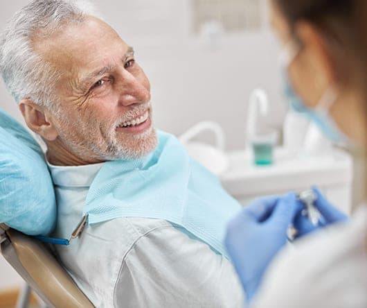 Smiling senior man talking with his dentist