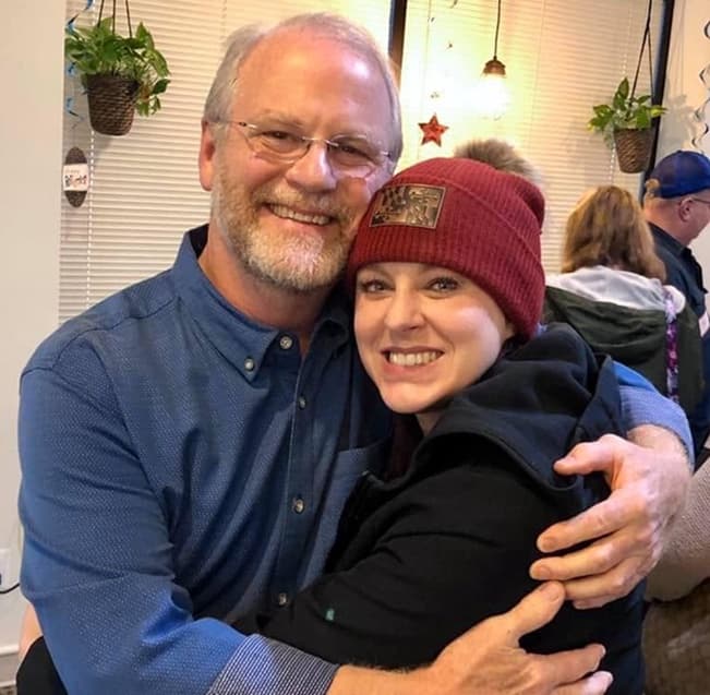 Happy patient hugging a family member in the Landmark Smiles office