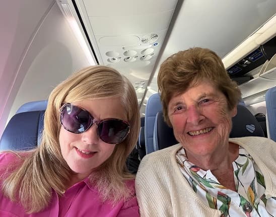 Two happy Landmark Smiles patients taking a selfie on a plane