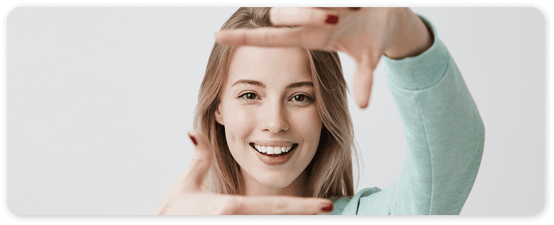 Smiling patient holding a clear aligner